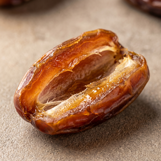 Medjool date cut to show the soft caramel flesh, macro