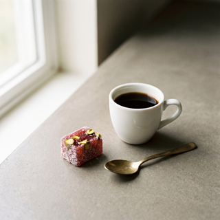 Pomegranate and Pistachio Turkish Delight beside a coffee cup showing size
