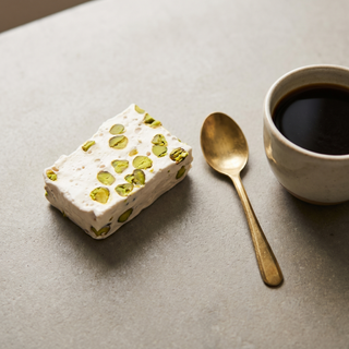 Iranian Pistachio Nougat beside a coffee cup showing size